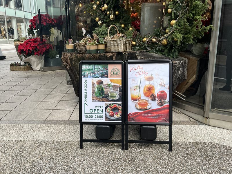 表参道のカフェgreenhouseの外観。クリスマス装飾と植物に囲まれた入口の様子。クリスマスの特別メニューの看板